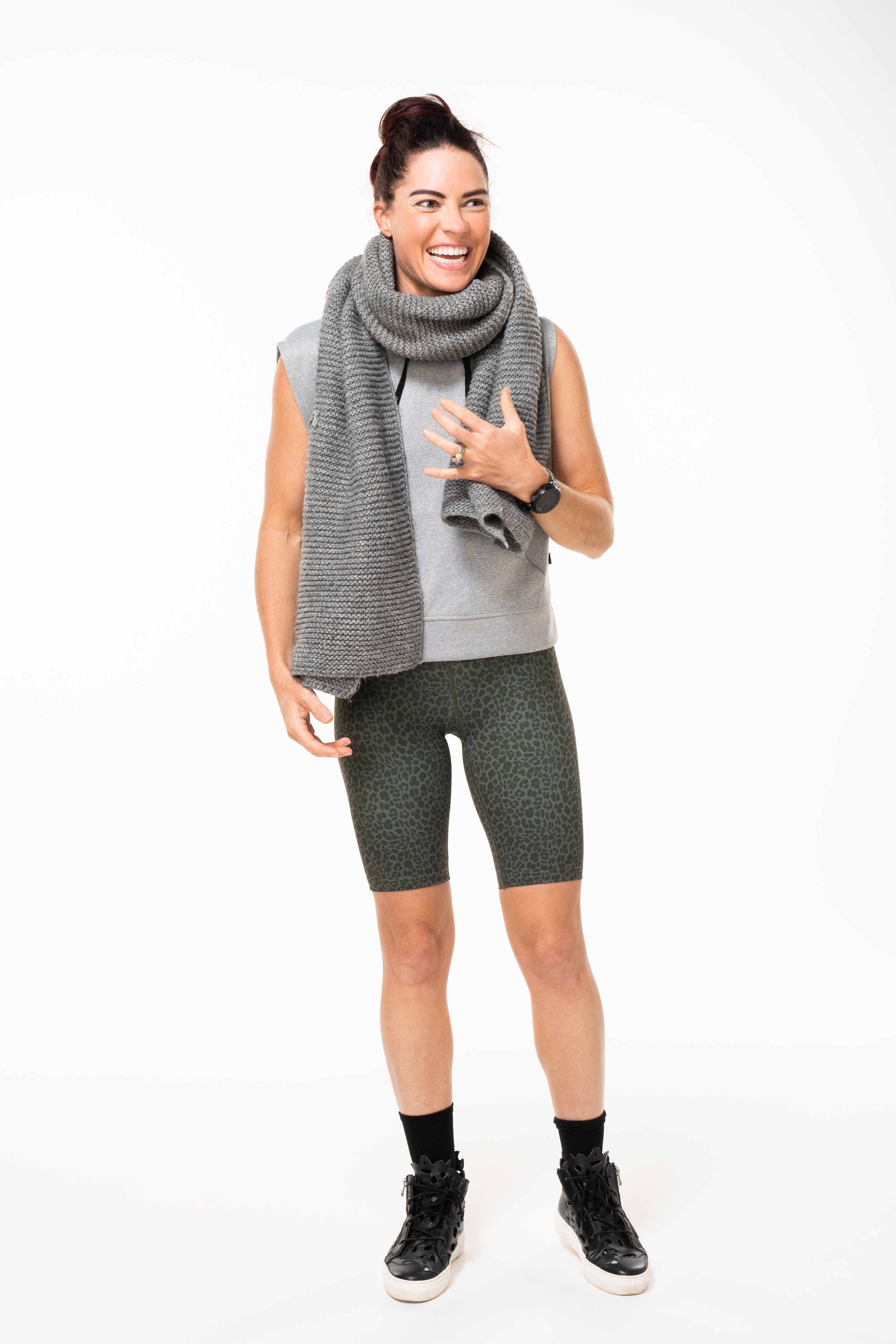 Model wearing Panther Pedal Pumpers with grey tank and scarf. Long green animal print workout shorts with light compression.
