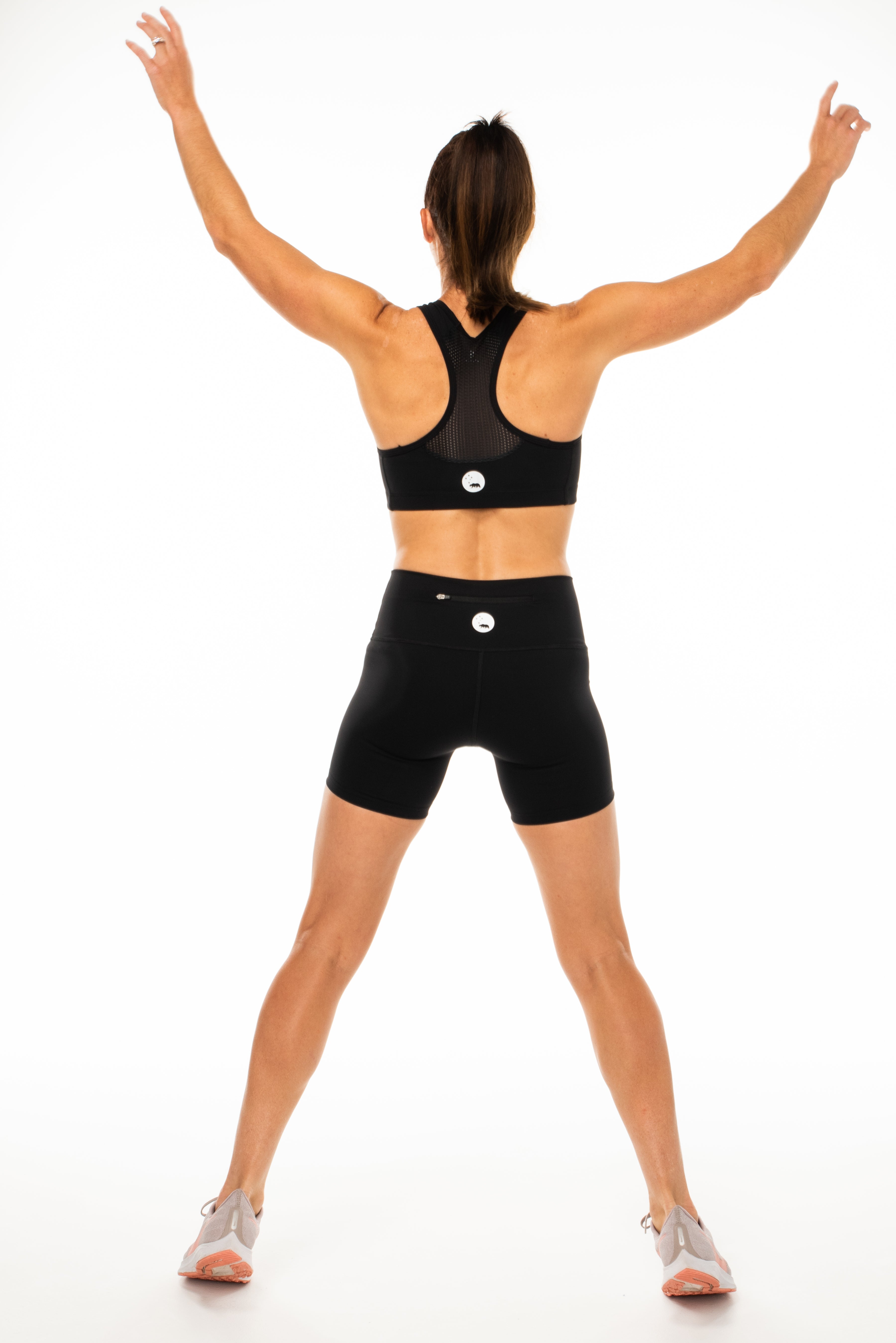 Back view Black Little Bit Longer Shorts. Women's high-waisted black workout shorts. Black athleisure shorts.