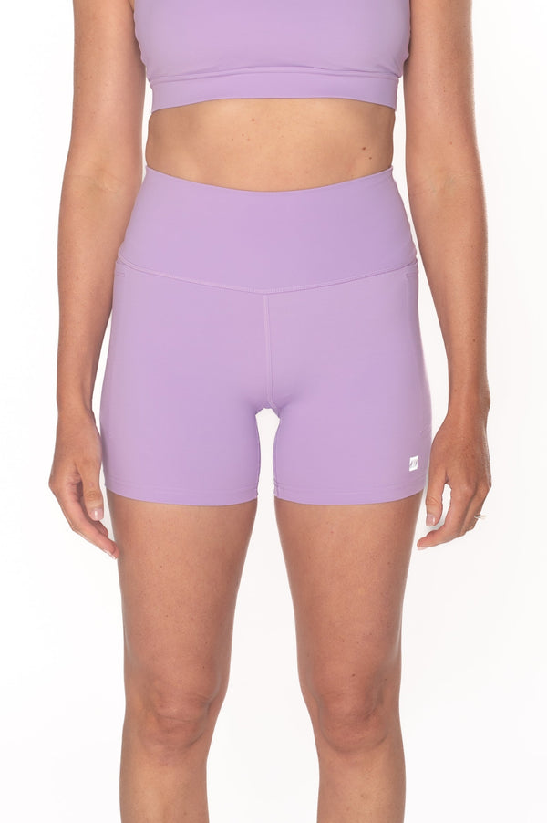 Woman wearing a purple athletic outfit on a white background