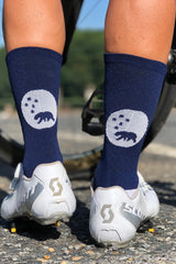 Back view wearing WYN republic Navy Flagship Socks in white cycling shoes. Navy mid-calf socks.