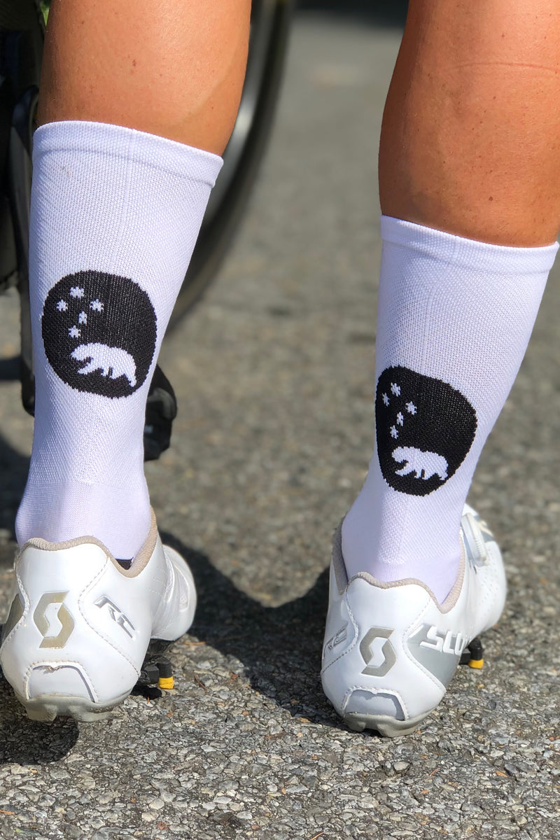 Back view wearing White Flagship Socks in white cycling shoes. White diamond weave mid-calf socks.