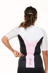 Model placing nutrition gel in back pocket of sleeved triathlon top. Women's tri top with pockets.
