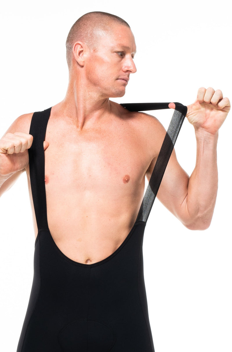 Model wearing men's black Velocity 2.0 Cycling Bib Shorts. Cycling shorts with stretch straps for comfort.