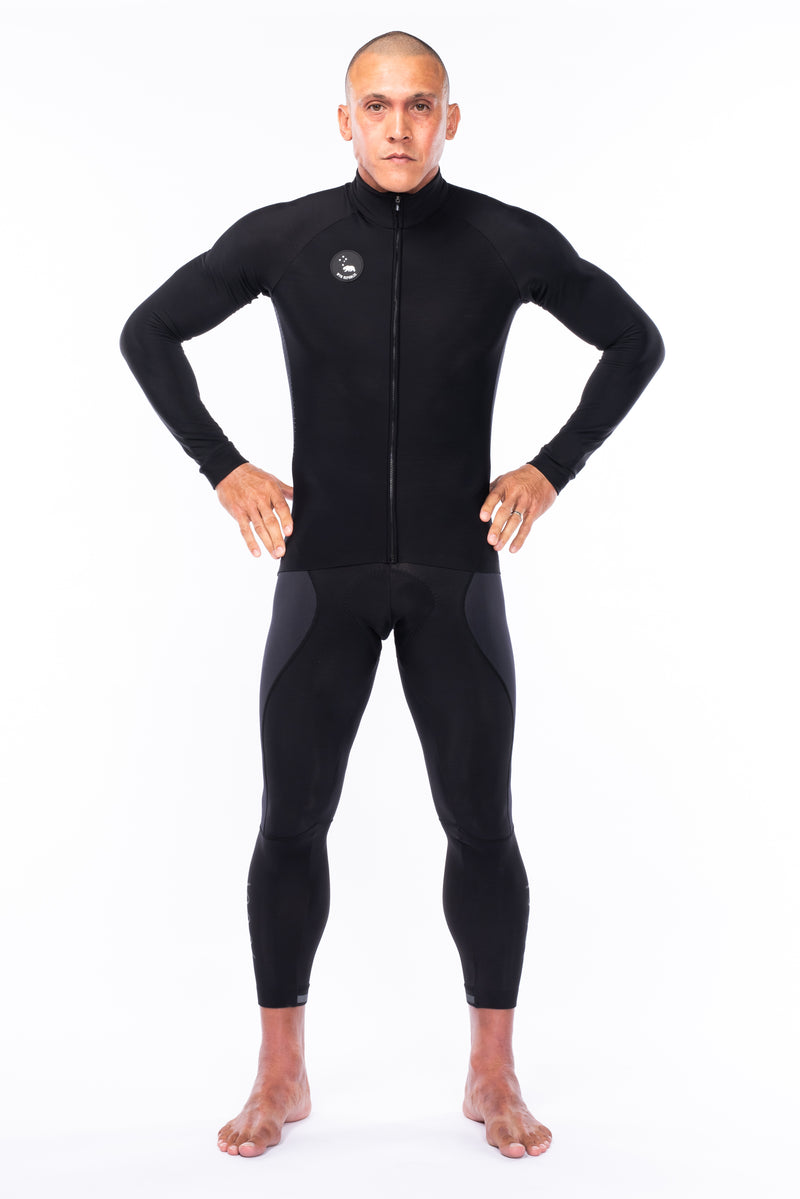 Model wearing thermal black cycling bib tights with a black thermal jacket.