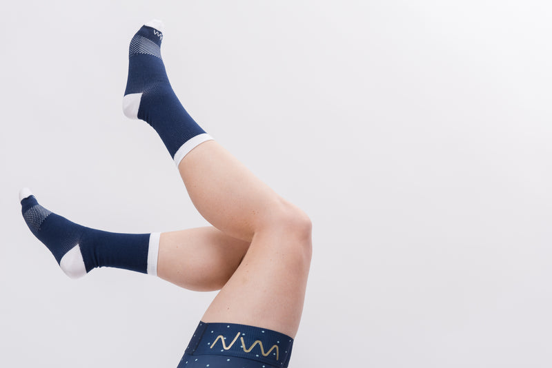 Legs in air wearing WYN republic Women's Navy Captain socks. Navy cycling socks with white detail.