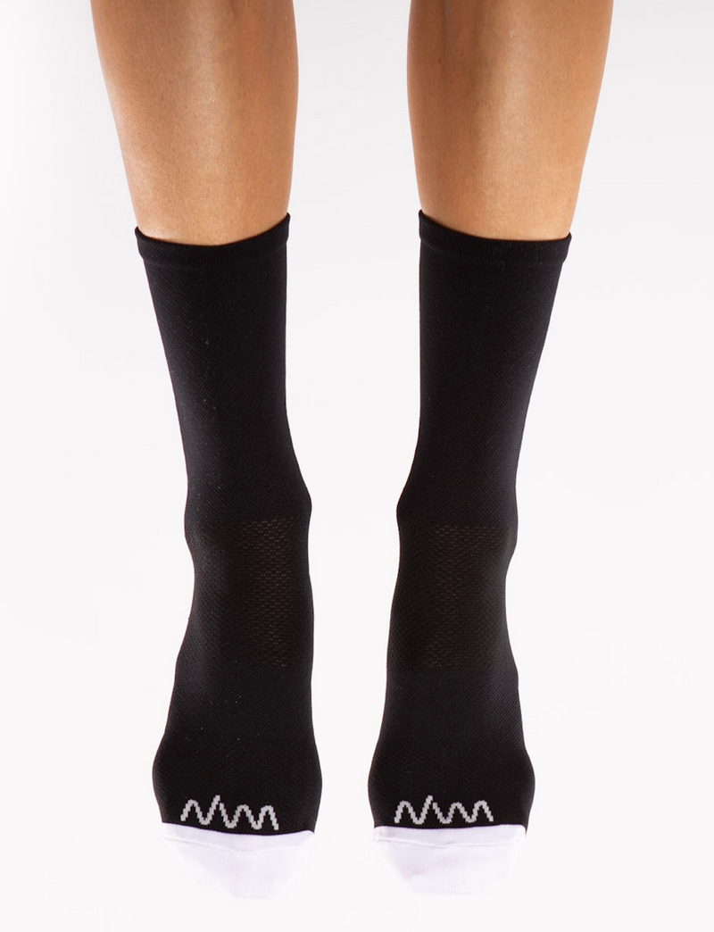 Front view Flagship socks. Mid-calf black cycling/running socks with white toe box and logo.