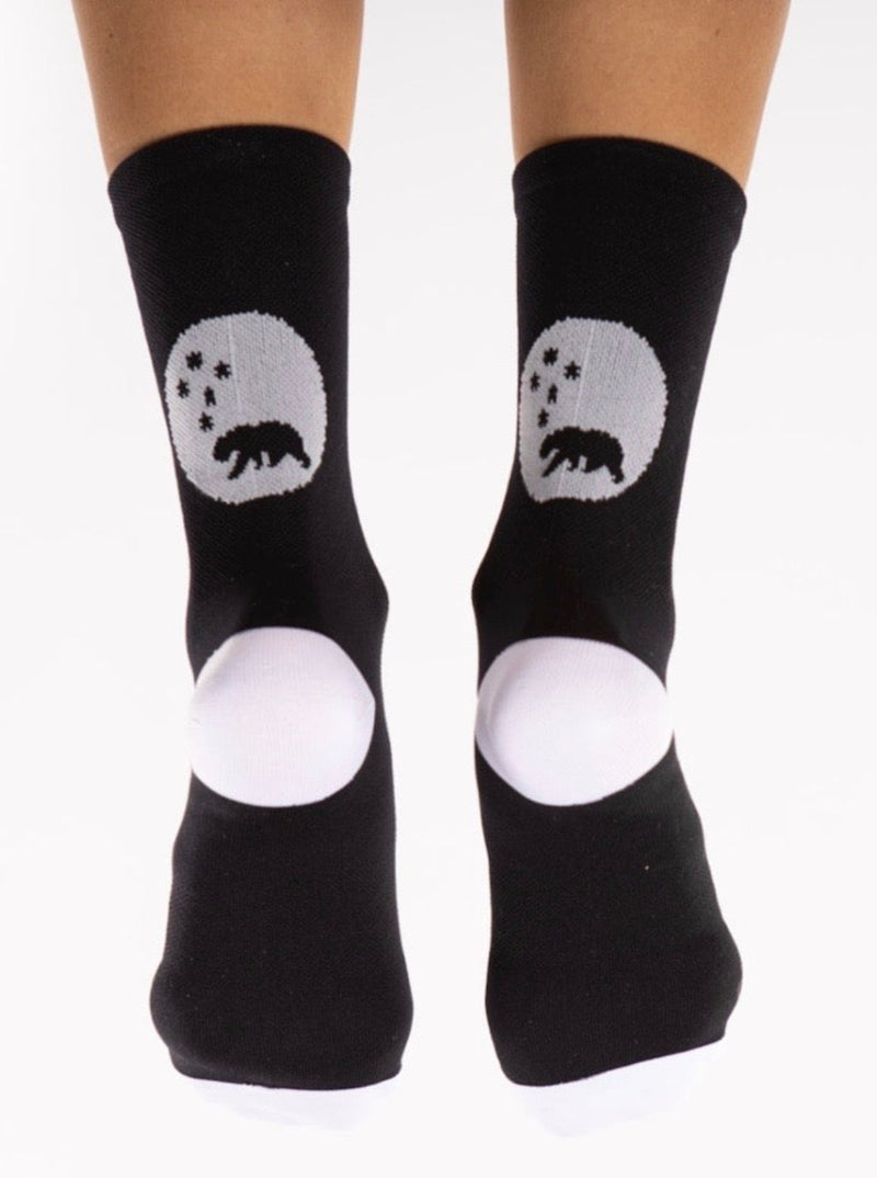 Back view of WYN republic Flagship Socks. Black cycling/running socks with white bear logo and heel.