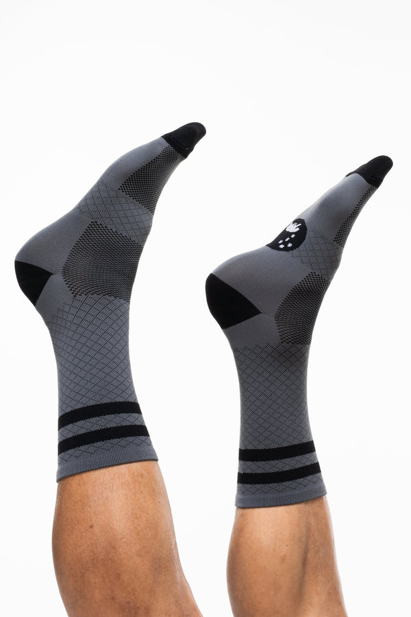 Legs in the air showing Grey Flagship socks. Mid-calf grey socks with two black strips on calf.