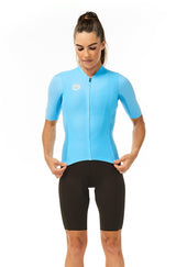 Model wearing women's mocha Velocity Cycling Bib Shorts with blue jersey. Aero cycling kit.