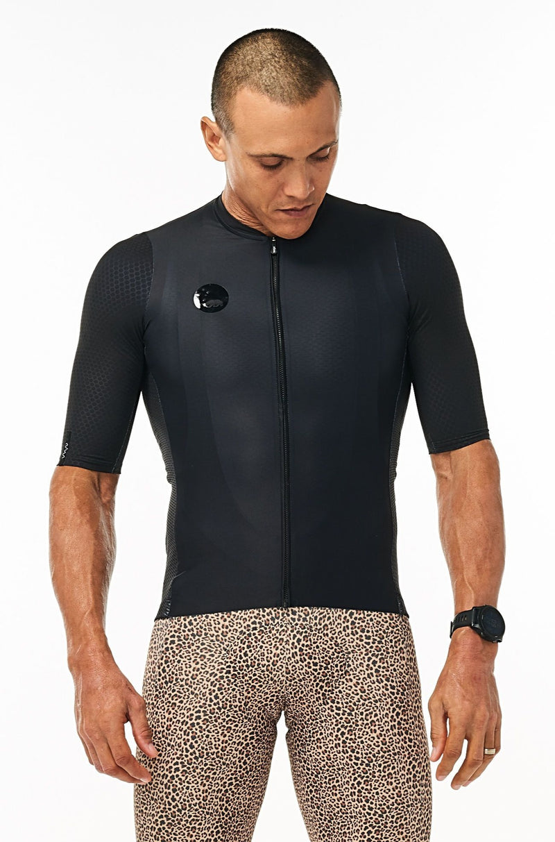 Model wearing men's Onyx Hex Racer Jersey with WYN republic Wildcat Bib Shorts. Bold cycling kit.
