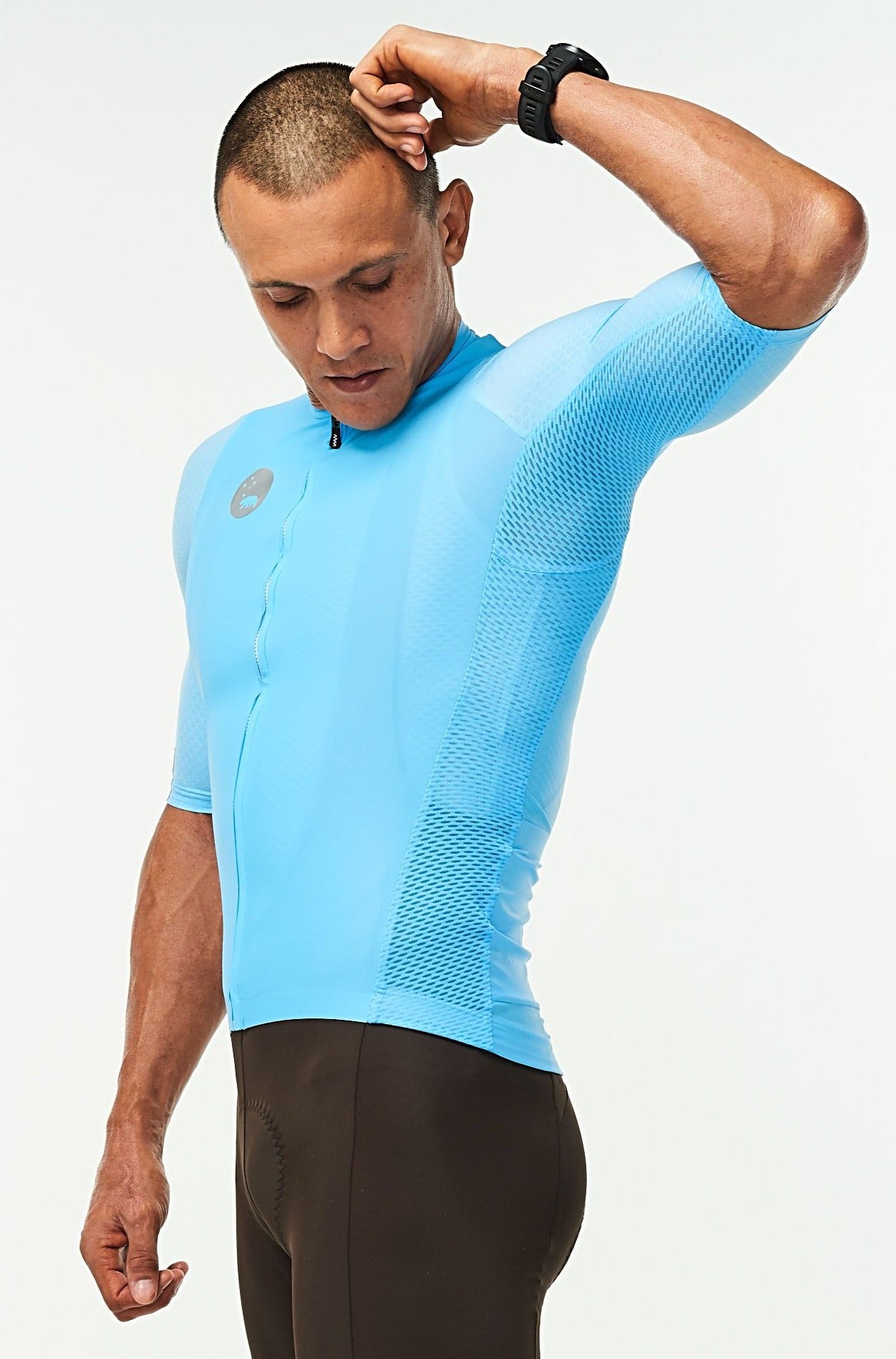 Model lifting left arm of men's Hex Racer Jersey. Flexible blue cycling jersey with mesh panels.