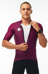 Model zipping men's Tyrian Hex Racer Jersey. Purple cycling jersey with flip-lock zipper.