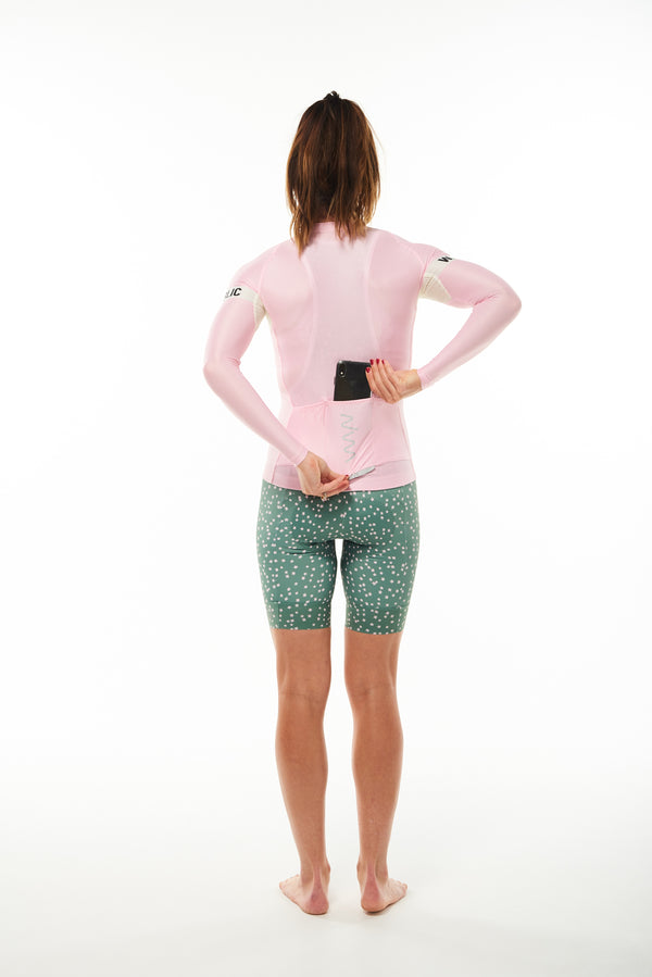 Model placing phone in back pocket of Carly Summer Long Sleeve Jersey. Cycling jersey with storage.
